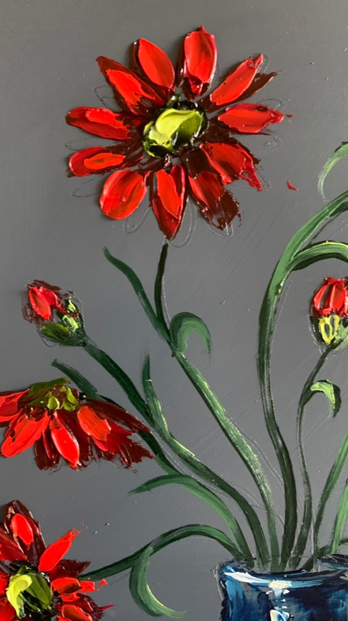 Red daisies in blue vase