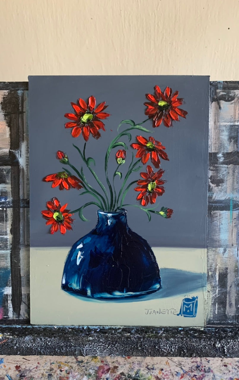 Red daisies in blue vase