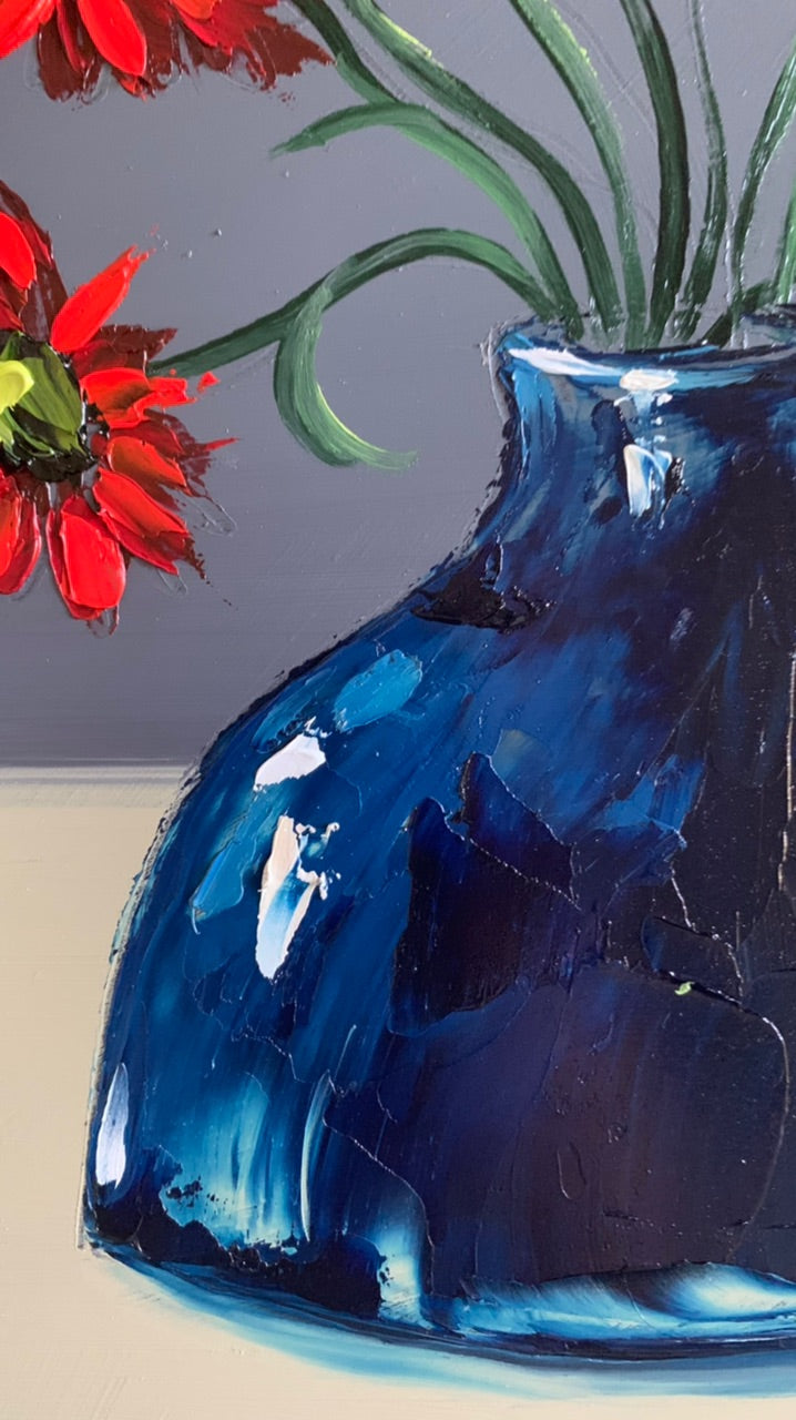 Red daisies in blue vase